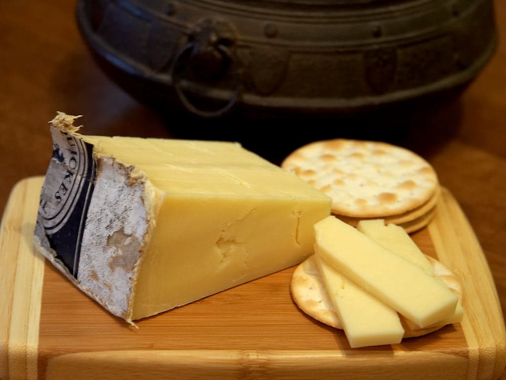 A traditional cloth-wrapped farmhouse cheddar wheel, the style Devon's best producers still make by hand