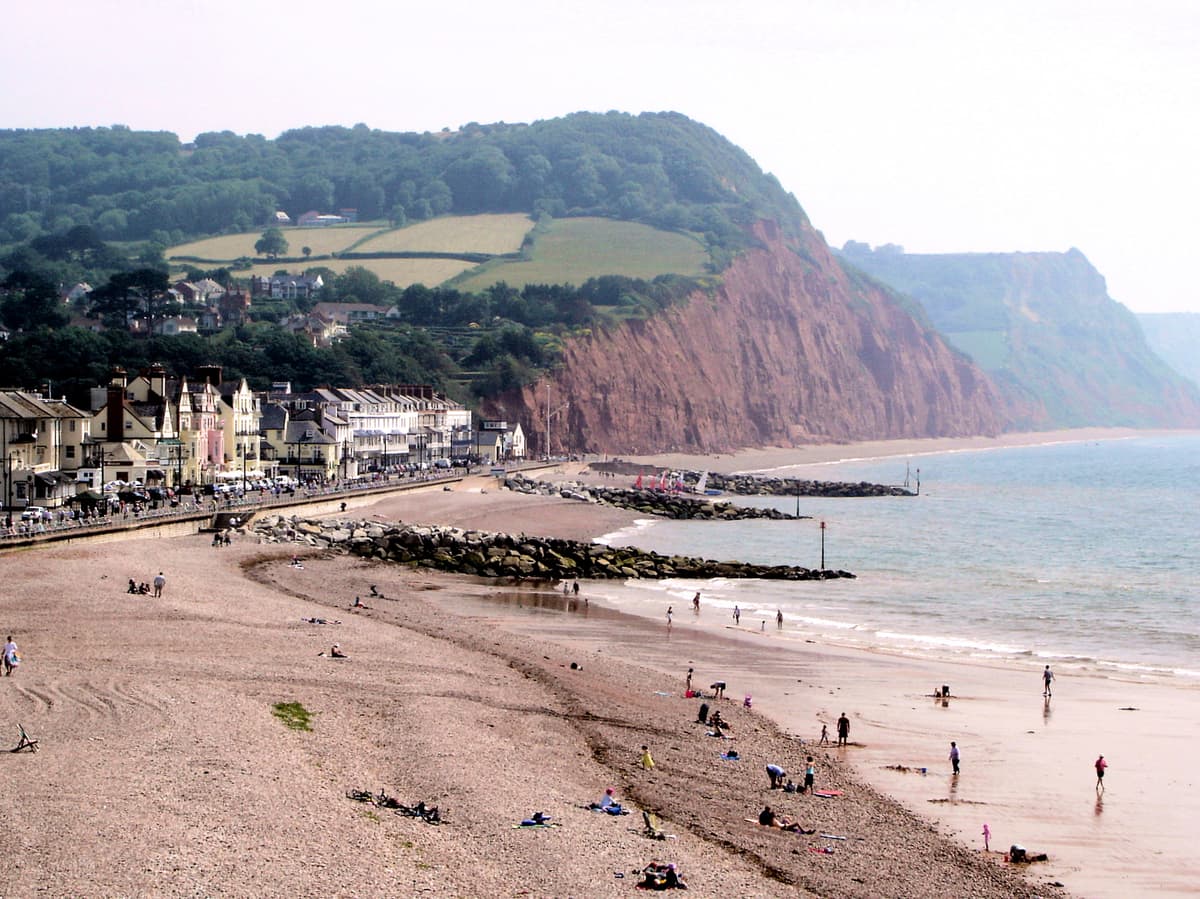 Sidmouth beach, backed by Regency buildings and red Jurassic Coast cliffs